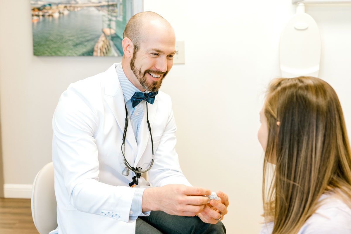 Dentist in a white coat with arms crossed at Thrive Family Dental in Wilmington, NC
